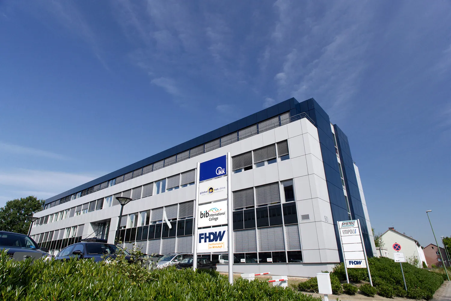 Gebäude der FHDW in Bielefeld mit FHDW-Schild im Vordergrund